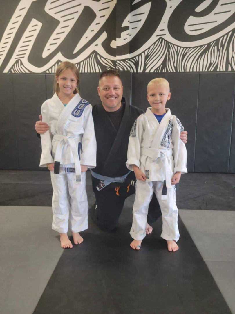 A family of father, daughter, and son participating in jiu jitsu together